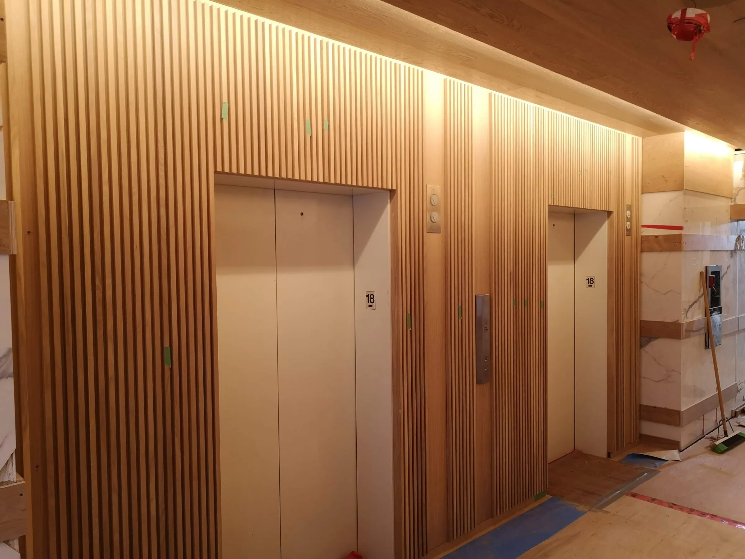 Slat elevator lobby — White oak and marble